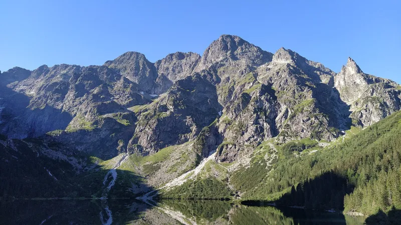 Rocky peaks of the Tatra Mountains reflected in the lake of Morskie Oko in Poland.