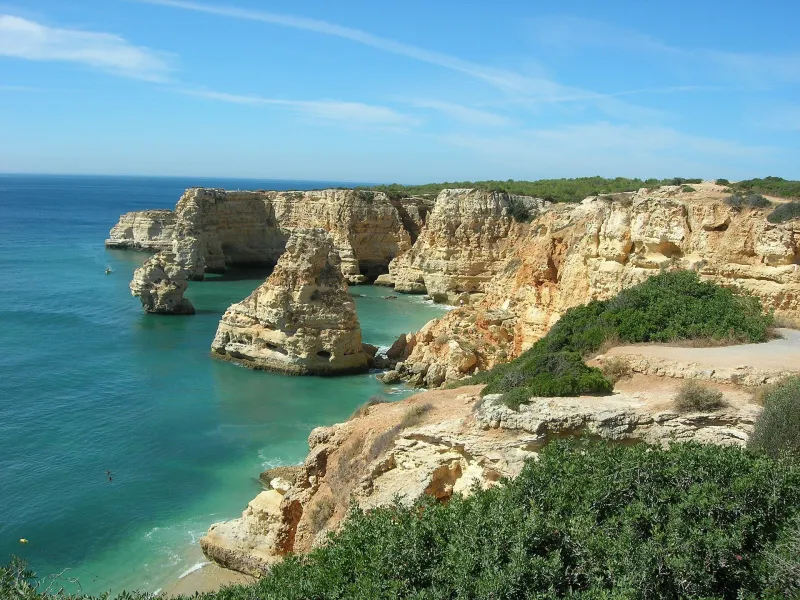 Golden limestone cliffs and turquoise sea at Praia da Marinha on the Algarve coast.