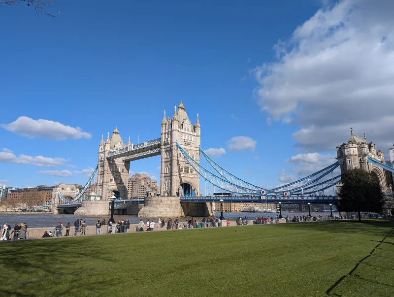 Tower Bridge on the Thames in London seen from the lawn on a bright day.